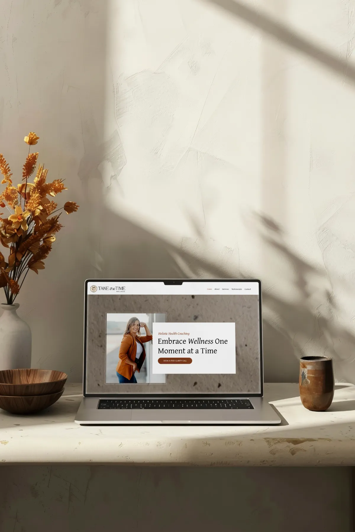 Take the Time Wellness website on a laptop in a warm, minimalist setting for a holistic coaching company, website design by Dream Wild Studio
