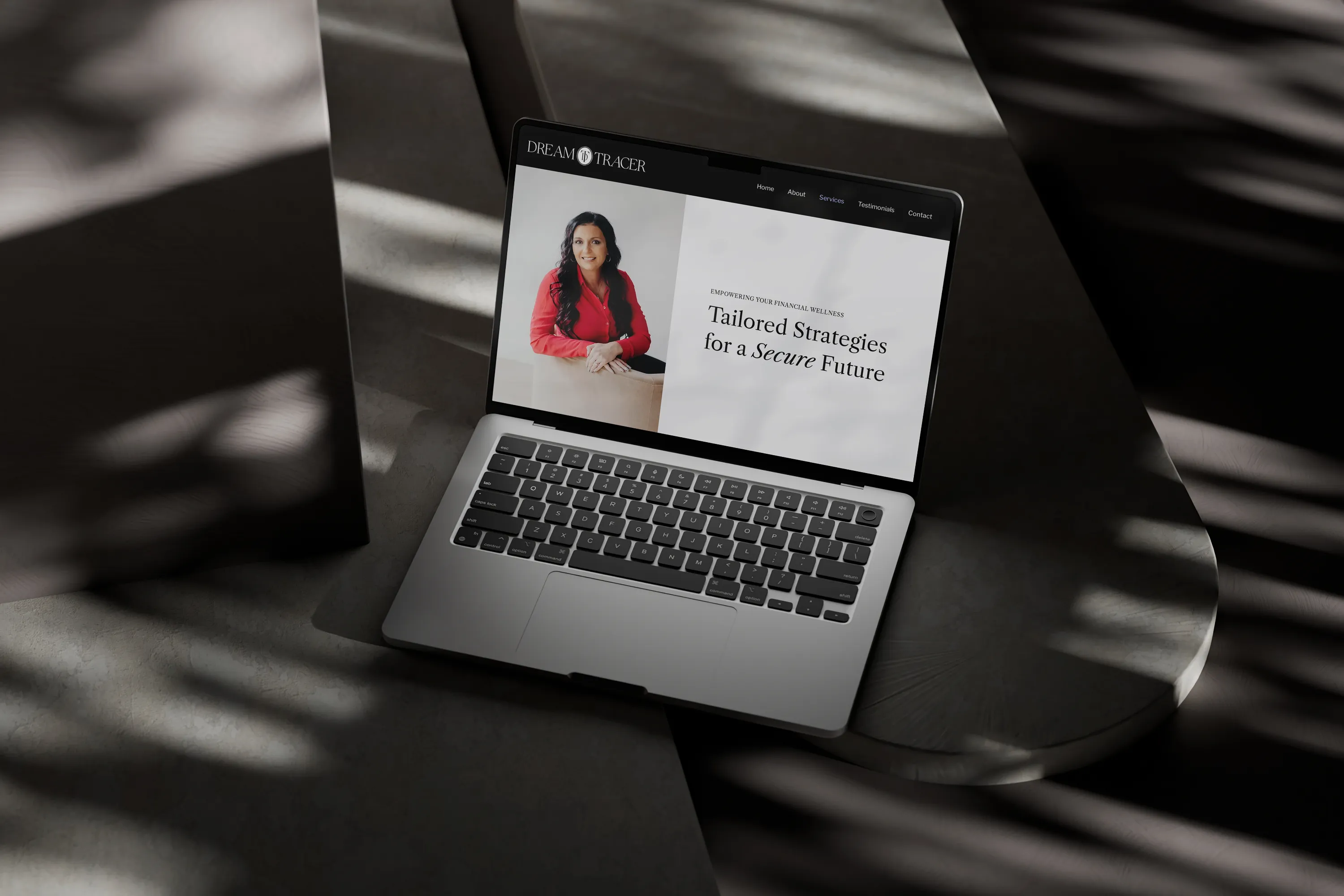 The laptop displays the website design for a financial strategist. Website design by Dream Wild Studio.