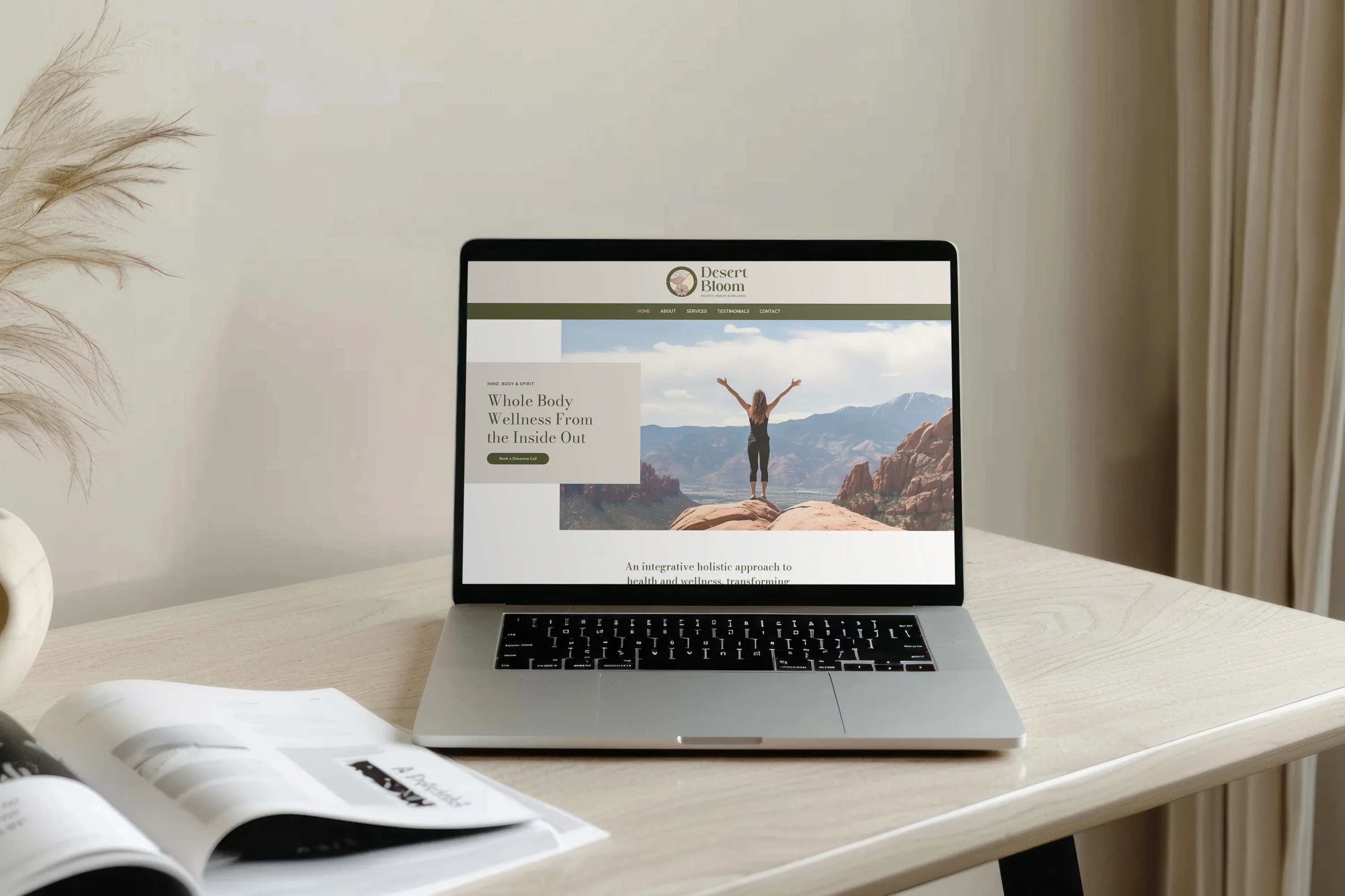 Desert Bloom Website Design on Laptop Desert Bloom website displayed on a MacBook on a table for a holistic wellness company, website design by Dream Wild Studio