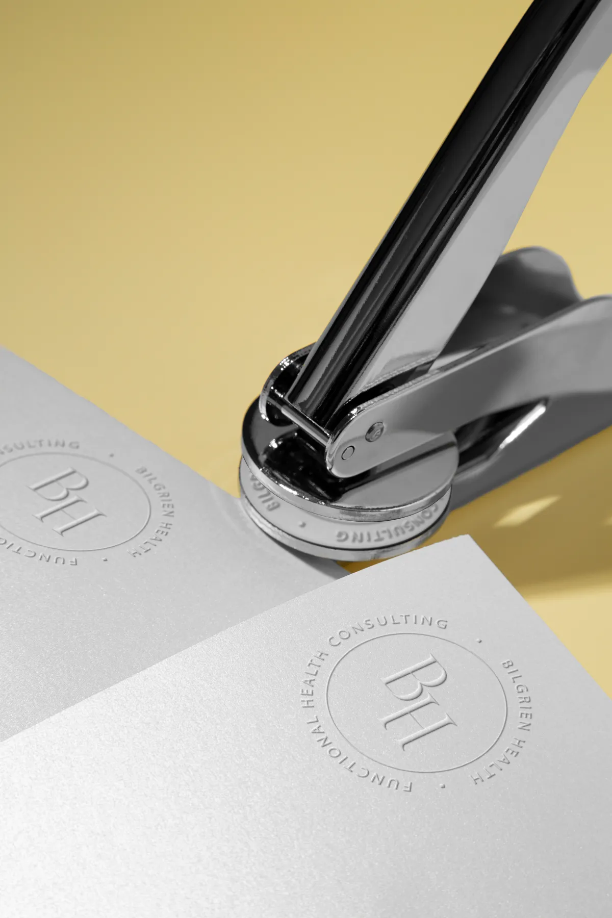 Bilgrien Health Embossed Logo Stamp Embossed stamp pressing the BH monogram seal into paper for holistic health consultant Bilgrien Health, branding by Dream Wild Studio
