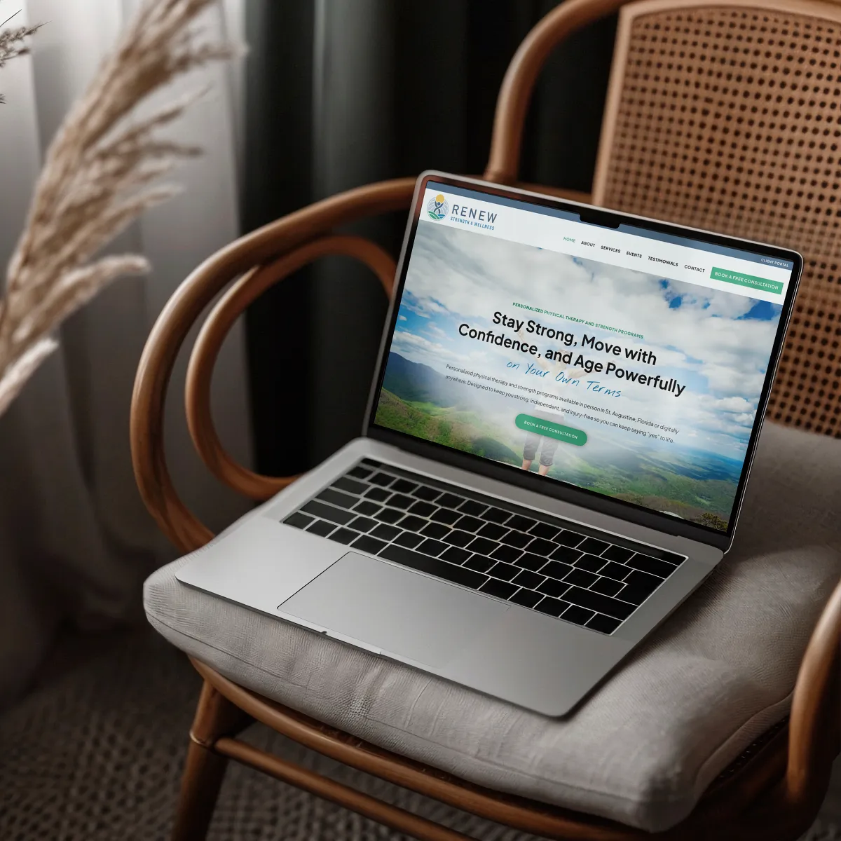 A laptop displaying the wellness website for a physical therapy business, is placed on a cushioned wooden chair in a cozy setting. Website design by Dream Wild Studio. Wild Studio. A laptop displaying the wellness website for a physical therapy business, is placed on a cushioned wooden chair in a cozy setting. Website design by Dream Wild Studio. Wild Studio.